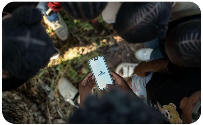 Person holding a cellphone with the Vumba logo